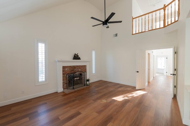 unfurnished living room featuring a fireplace, vaulted ceiling, dark hardwood / wood-style floors, and ceiling fan