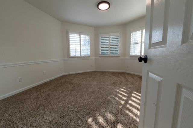 carpeted empty room featuring a wealth of natural light