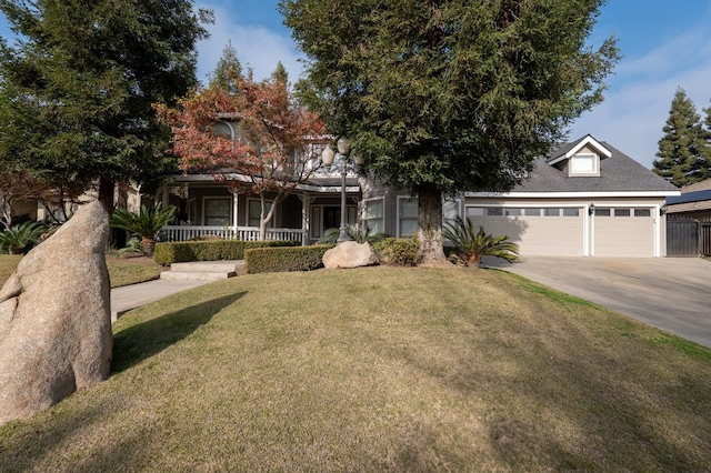 view of front of home featuring covered porch, a front yard, and a garage