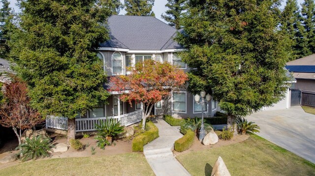 view of property hidden behind natural elements with a front yard