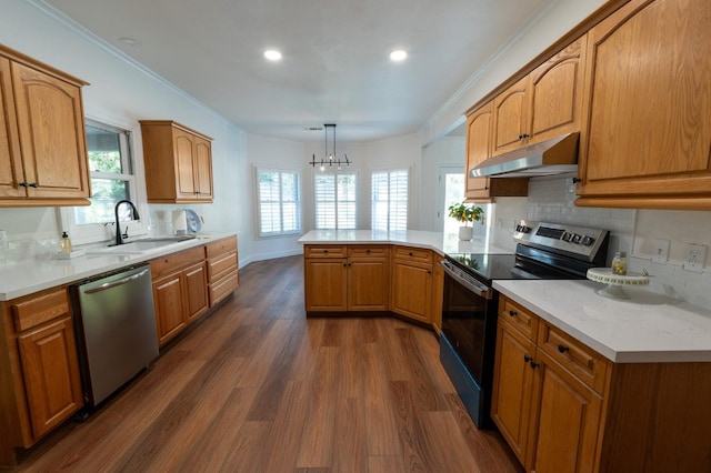 kitchen featuring dark wood-type flooring, stainless steel appliances, pendant lighting, sink, and kitchen peninsula