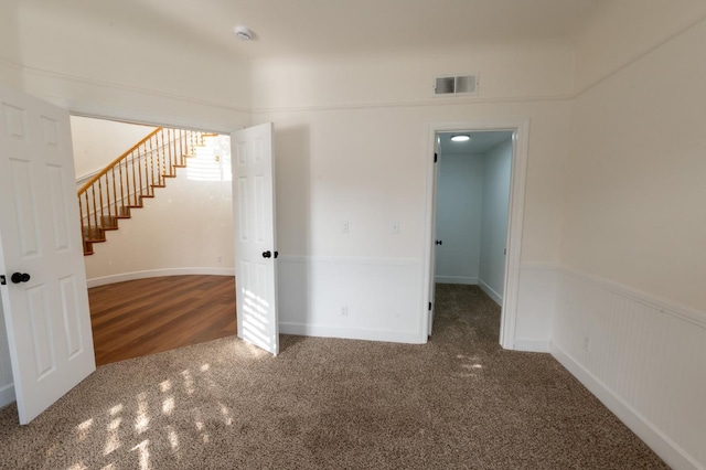 spare room with dark colored carpet