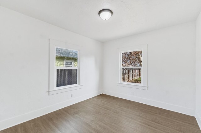 spare room featuring plenty of natural light and dark hardwood / wood-style floors