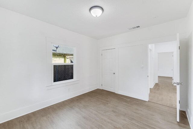 unfurnished room with wood-type flooring