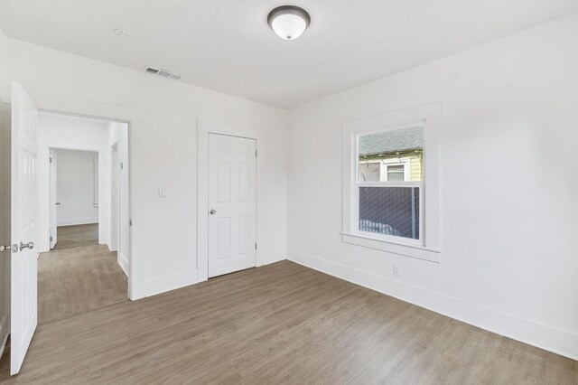 unfurnished bedroom featuring a closet and hardwood / wood-style flooring