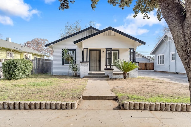 bungalow-style house with covered porch and a front yard