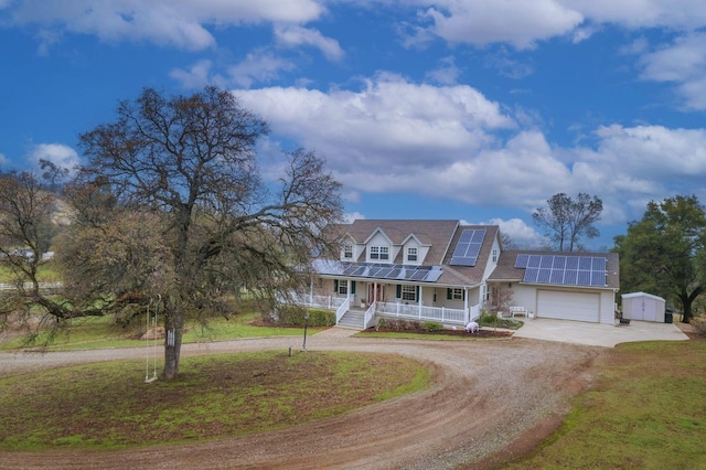 view of front of house with solar panels, covered porch, an outdoor structure, and a front lawn