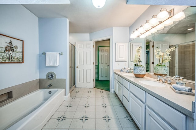 bathroom featuring plus walk in shower, vanity, and tile patterned floors