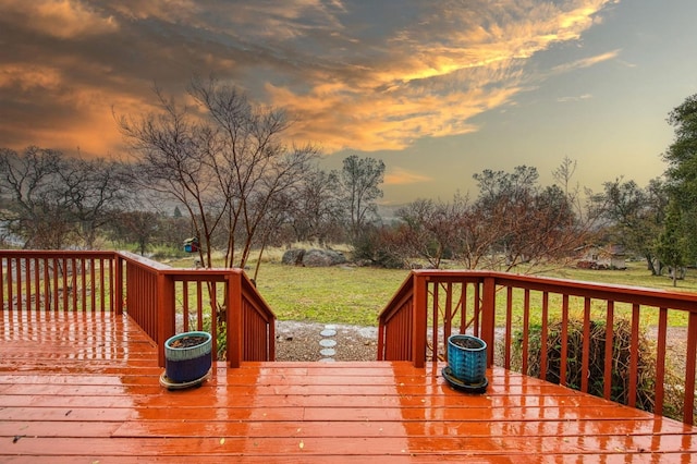 deck at dusk featuring a yard