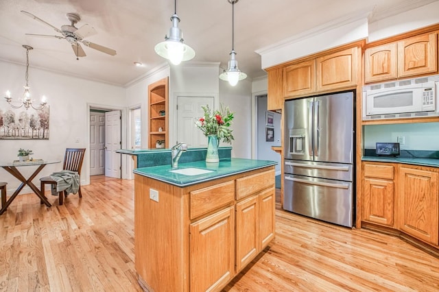 kitchen with stainless steel refrigerator with ice dispenser, white microwave, sink, pendant lighting, and light hardwood / wood-style floors