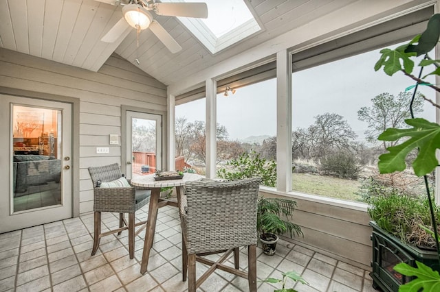 sunroom / solarium featuring vaulted ceiling with skylight, ceiling fan, and a healthy amount of sunlight