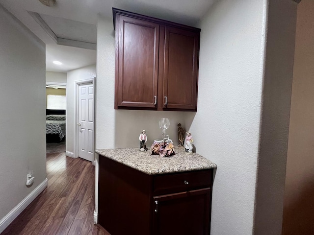 bar with dark brown cabinetry and dark wood-type flooring