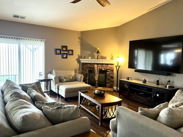 living room featuring dark hardwood / wood-style floors, ceiling fan, and a fireplace