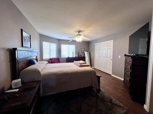 bedroom featuring ceiling fan, dark hardwood / wood-style flooring, and a textured ceiling