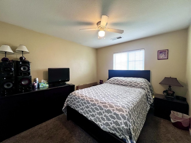 carpeted bedroom with ceiling fan and a textured ceiling