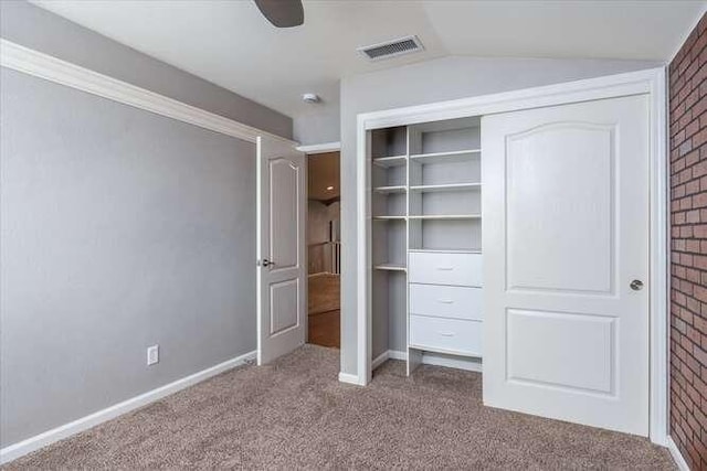 unfurnished bedroom featuring ceiling fan, lofted ceiling, light carpet, and a closet