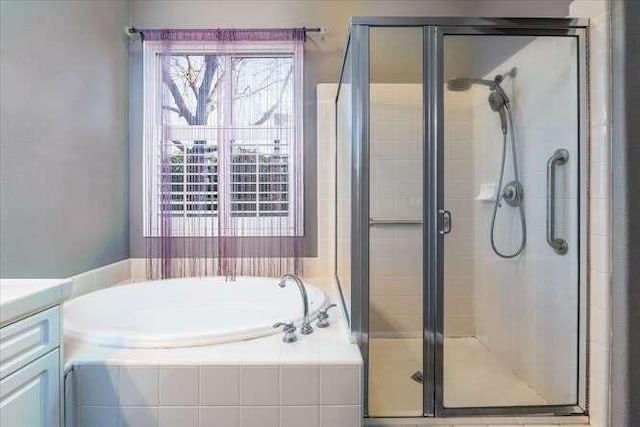 bathroom with vanity and separate shower and tub