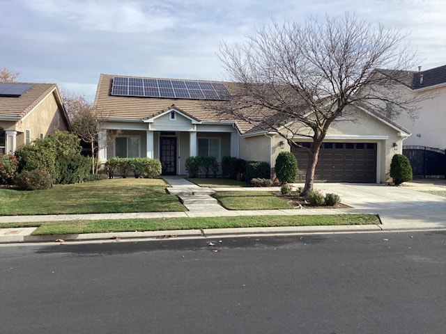 view of front of home with solar panels, a garage, and a front lawn