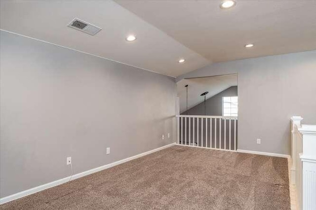 spare room with carpet flooring and vaulted ceiling