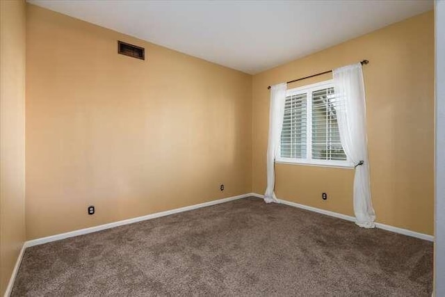 spare room featuring dark carpet