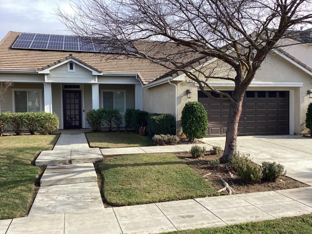 single story home featuring a garage, a front yard, and solar panels