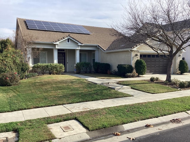 single story home with solar panels, a porch, a garage, and a front lawn