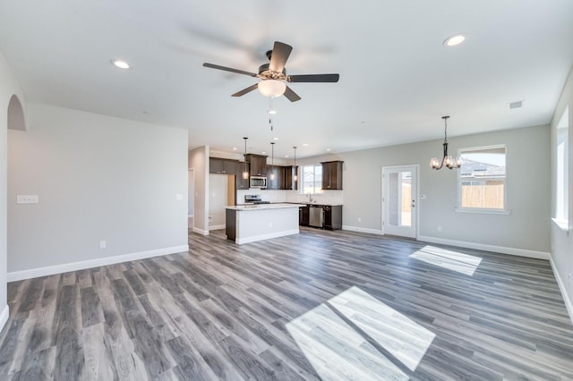 unfurnished living room featuring ceiling fan with notable chandelier, dark hardwood / wood-style floors, and sink