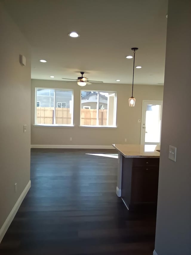 kitchen featuring baseboards, recessed lighting, dark wood-style flooring, light countertops, and decorative light fixtures