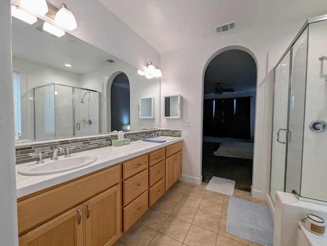 bathroom featuring vanity, tile patterned floors, ceiling fan, decorative backsplash, and a shower with shower door