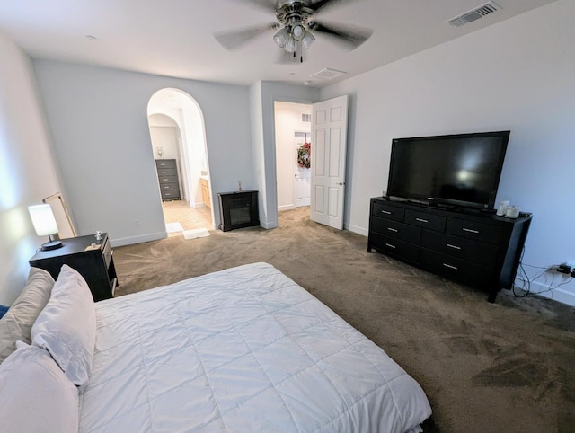 carpeted bedroom with ceiling fan and connected bathroom