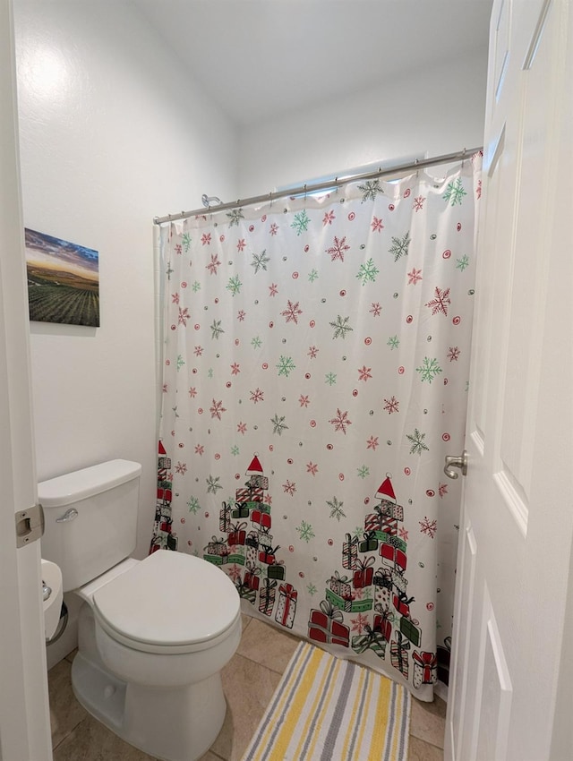 bathroom featuring tile patterned floors, a shower with shower curtain, and toilet