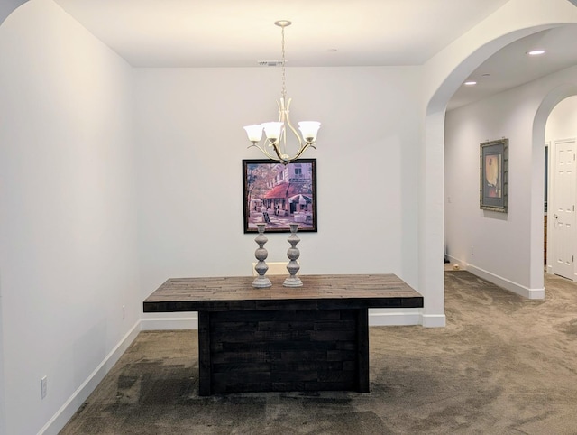 carpeted dining room featuring an inviting chandelier