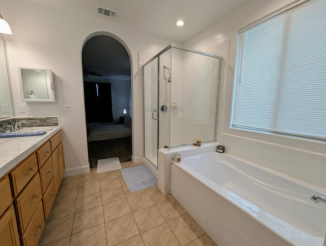 bathroom featuring tile patterned floors, vanity, and shower with separate bathtub