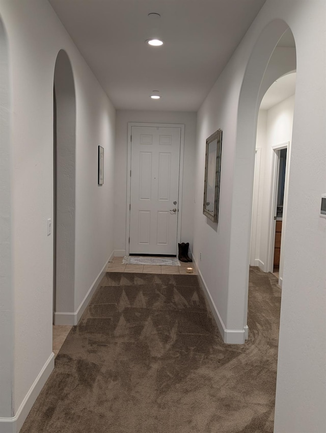 hallway with dark colored carpet