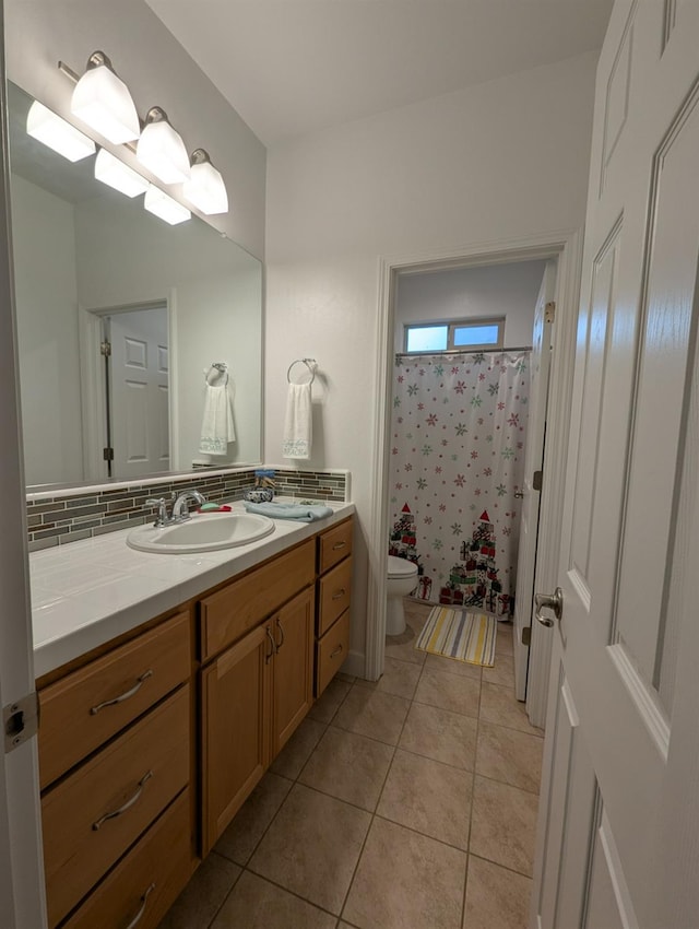 bathroom with backsplash, tile patterned flooring, vanity, and toilet