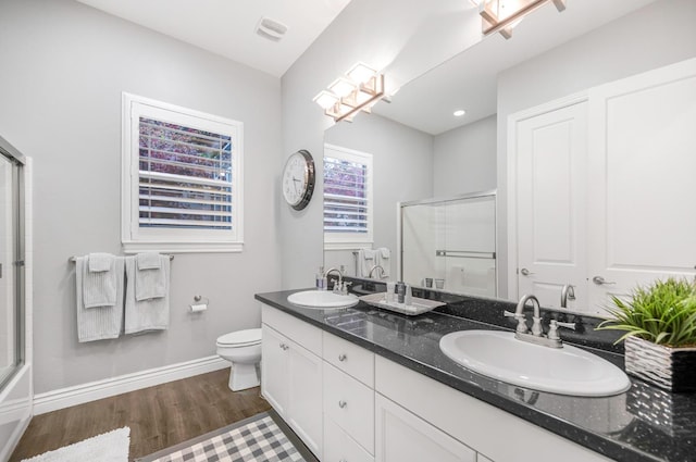 bathroom featuring an enclosed shower, vanity, hardwood / wood-style flooring, and toilet