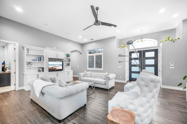 living room with dark hardwood / wood-style flooring and ceiling fan