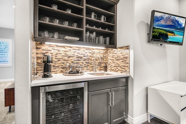 bar featuring sink, wine cooler, and backsplash