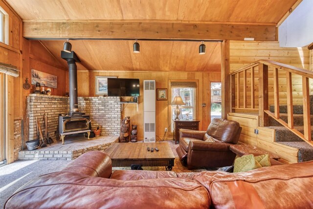 carpeted living room with a wood stove, wood walls, wood ceiling, and lofted ceiling with beams