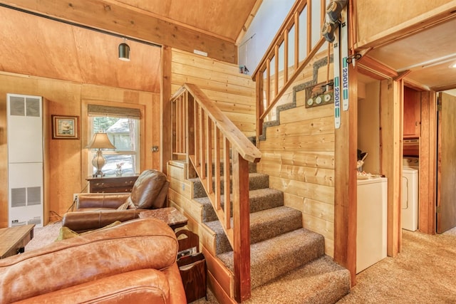 staircase with washing machine and clothes dryer, carpet, and wood walls