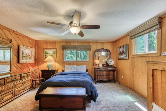 carpeted bedroom with multiple windows, ceiling fan, and a textured ceiling