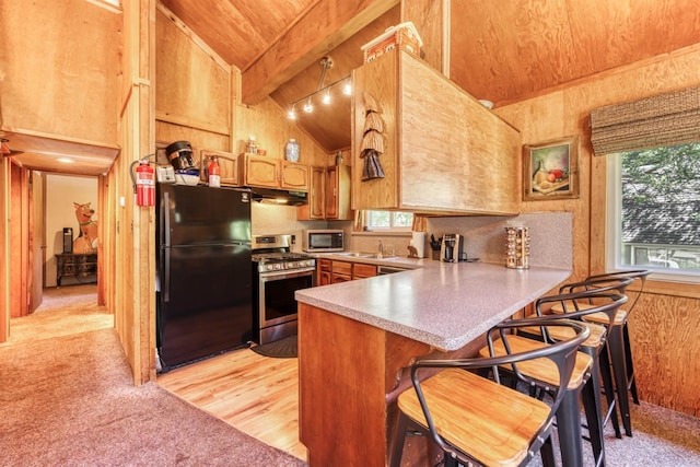 kitchen featuring stainless steel appliances, a kitchen breakfast bar, vaulted ceiling with beams, kitchen peninsula, and wood ceiling