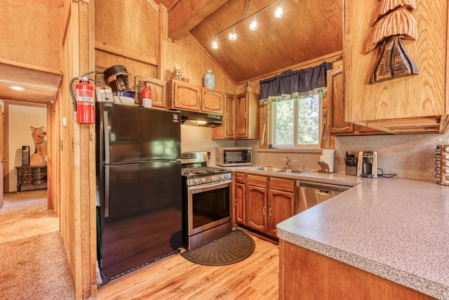 kitchen featuring appliances with stainless steel finishes, wood ceiling, sink, vaulted ceiling with beams, and light hardwood / wood-style floors