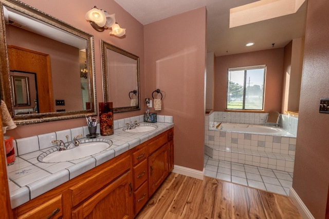 8510 E Nees Ave, Clovis, CA 93619 - full bath featuring double vanity, a garden tub, a skylight, and wood finished floors