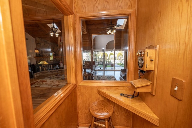 bar with ceiling fan and wooden walls