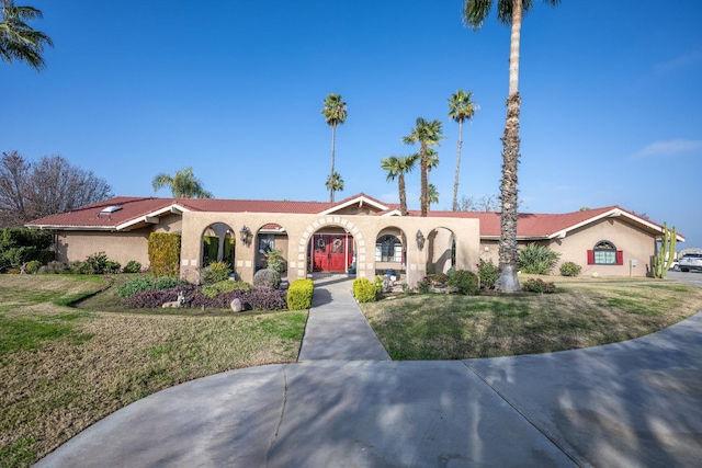 mediterranean / spanish-style house with a front lawn