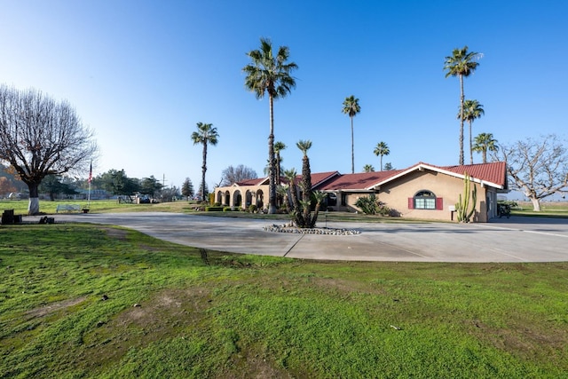 8510 E Nees Ave, Clovis, CA 93619 - view of front of home featuring stucco siding, curved driveway, and a front yard