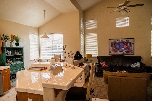 living room featuring ceiling fan, light tile patterned floors, and vaulted ceiling