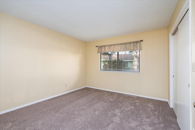 unfurnished bedroom featuring carpet floors, a closet, a textured ceiling, and baseboards