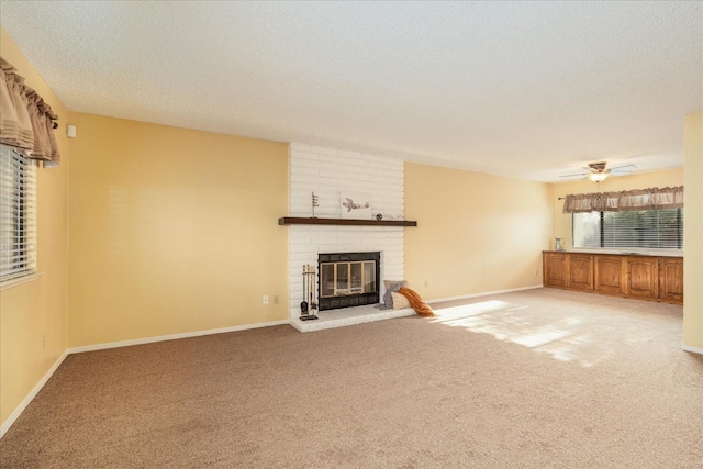 unfurnished living room featuring light carpet, a brick fireplace, baseboards, and a textured ceiling